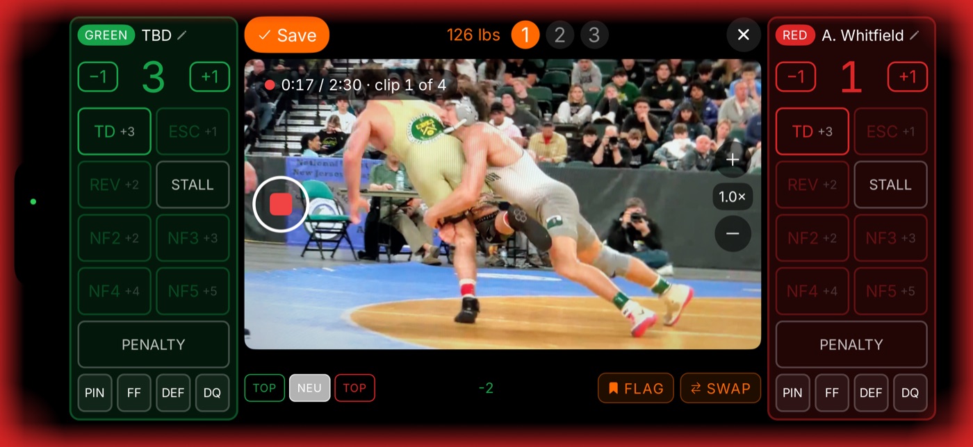 WrestlingT scoring and filming a bout on one phone, the camera in the middle with both wrestlers' scoring panels either side